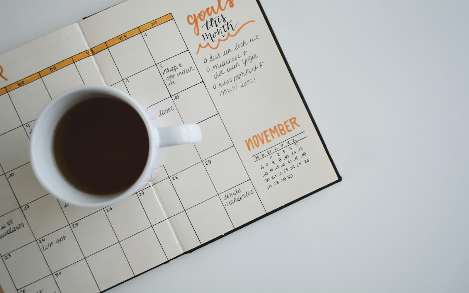 Open agenda met een kop koffie, de maand november staat aangegeven