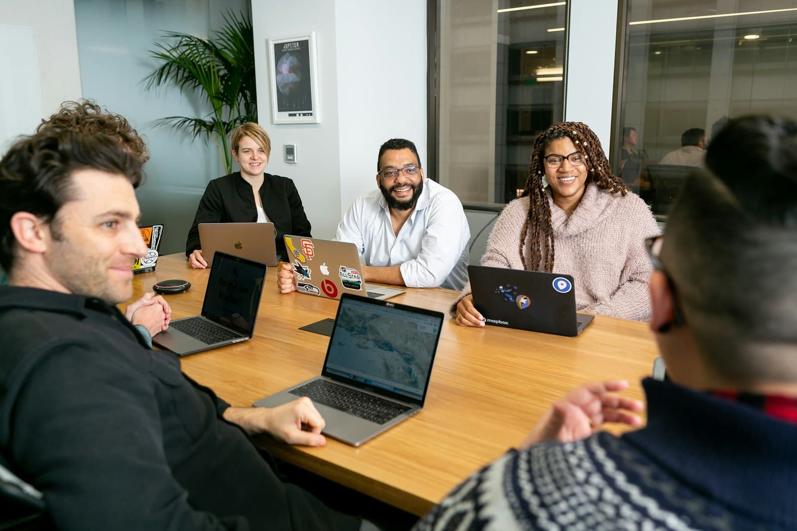 Team overlegt rond een tafel met laptops