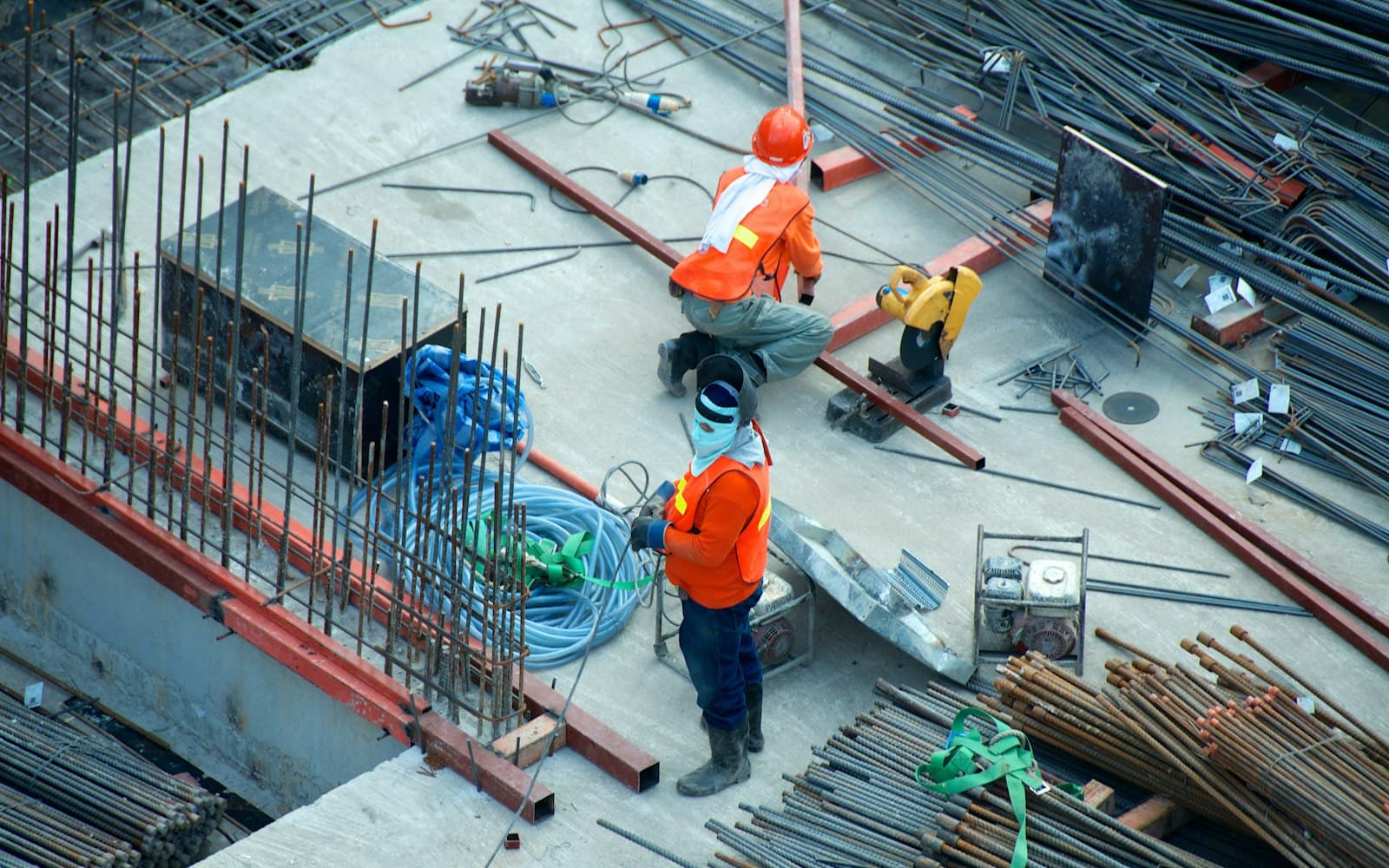 Bouwvakkers in oranje hesjes van bovenaf