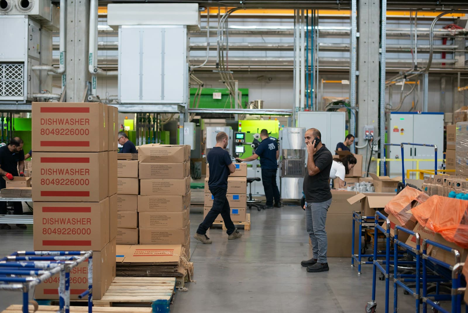 Medewerkers in een productiehal met dozen